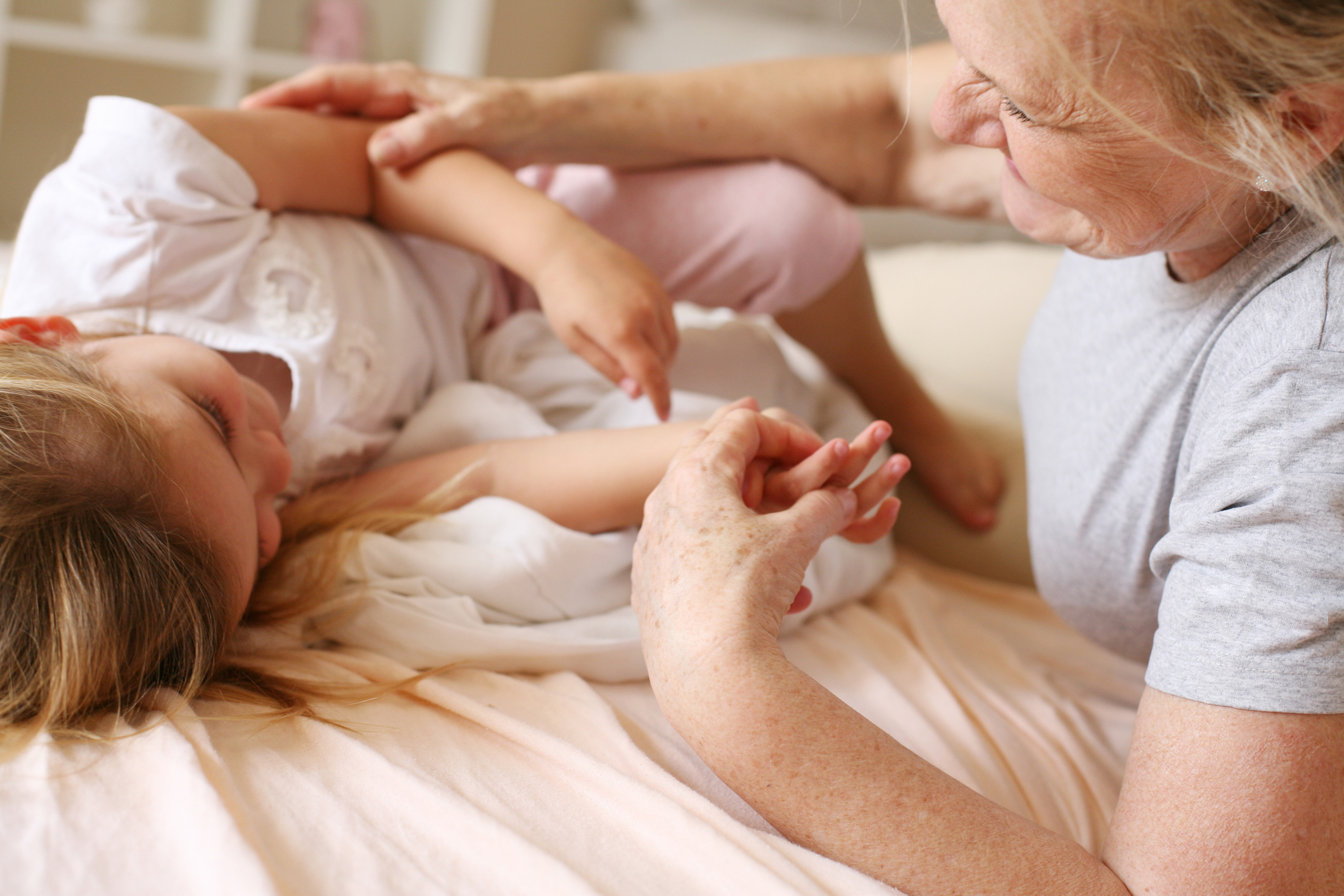 Grandmother with his granddaughter in bed.